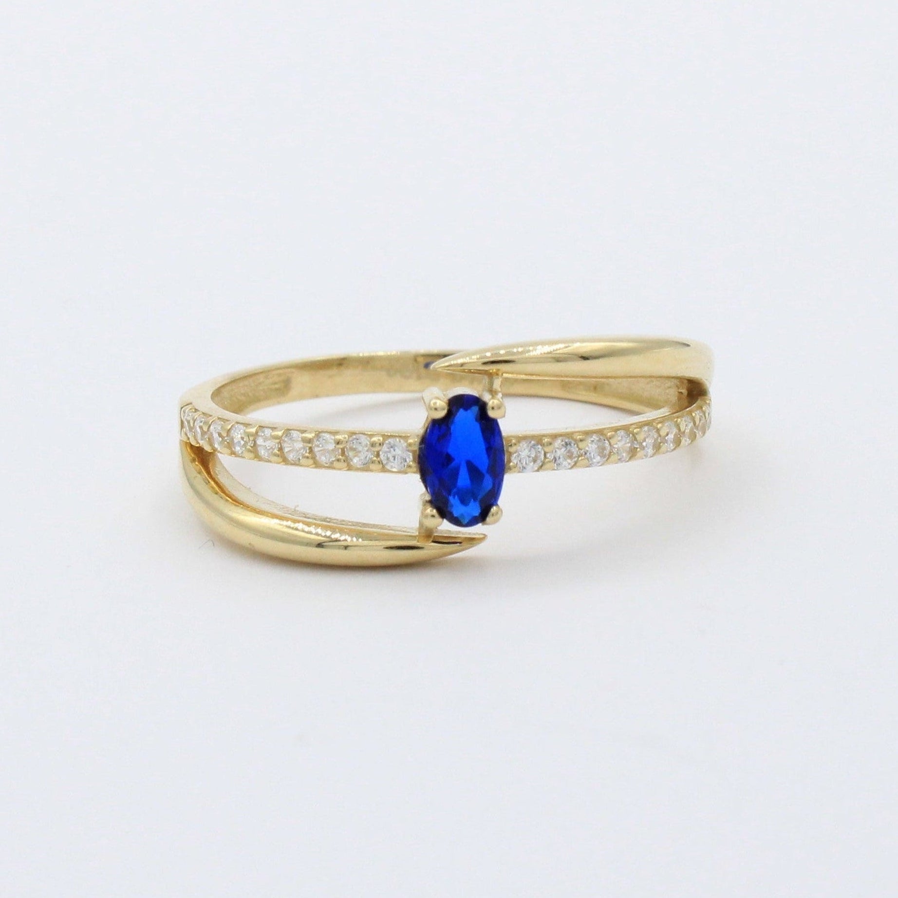Anillo de Oro 14k Diseño Cruzado con Zirconia Azul Oval y Carril de Zirconias mod. 10390